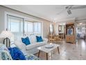 Bright living room with tiled floors, a white sofa with blue pillows, and balcony access showcasing ocean views at 1255 Tarpon Center Dr # 315, Venice, FL 34285