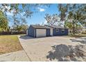 Side view of a blue home with a large, paved driveway leading to an attached garage at 1367 21St St, Sarasota, FL 34234
