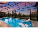 Relaxing screened-in pool area with two lounge chairs and spa offering a picturesque sunset view at 14803 Derna Ter, Bradenton, FL 34211