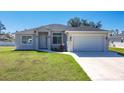 Well-manicured lawn and tidy landscaping complement this single Gathering home's neutral exterior at 2186 Yalta Ter, North Port, FL 34286