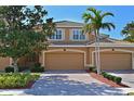 Charming home exterior featuring well-manicured landscaping, brick driveway, and two-car garage at 322 Winding Brook Ln # 103, Bradenton, FL 34212