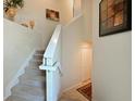 Elegant staircase with carpeted steps, white banister, and tile landing at 322 Winding Brook Ln # 103, Bradenton, FL 34212