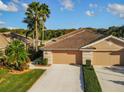 Overhead view of a single-story home featuring a tile roof, lush landscaping, and a spacious two-car garage at 375 Fairway Isles Ln, Bradenton, FL 34212