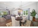 Open-concept dining area with a chandelier, hardwood floors, and seamless flow into the living room at 438 Whistler Gln, Bradenton, FL 34212