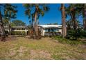 Charming single-story home featuring a well-maintained lawn and lush, tropical landscaping with beautiful palm trees at 231 Hourglass Way # V5, Sarasota, FL 34242