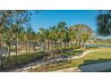 Lush landscaping with palm trees along walking path by community lake at 250 Sands Point Rd # 5101, Longboat Key, FL 34228