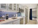 Kitchen with stainless steel appliances, counter space and blue backsplash at 250 Sands Point Rd # 5101, Longboat Key, FL 34228