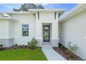 Charming single-Gathering home exterior featuring a modern front door entrance and manicured landscaping at 3294 Gowanda Ave, North Port, FL 34287