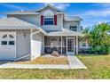 Inviting home entrance featuring a charming screened-in porch and lush landscaping at 6145 Bonaventure Ct, Sarasota, FL 34243