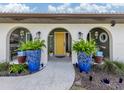 Welcoming front entrance with decorative plants and a bright yellow door at 641 Verrocchio Dr, Nokomis, FL 34275