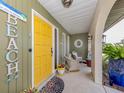 Cozy porch with a bright yellow door and charming beach-themed decor at 641 Verrocchio Dr, Nokomis, FL 34275