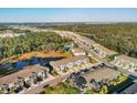Aerial view of a residential community with a pool, pond, green spaces, and long roads at 6634 Calypso Coral Ln, Sarasota, FL 34240