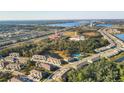 Aerial view of a residential community with a pool, pond, and surrounding green spaces at 6634 Calypso Coral Ln, Sarasota, FL 34240