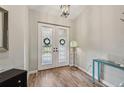 Welcoming foyer with wood flooring, a modern light fixture, and decorative glass double doors with a lovely transom at 7415 36Th E Ave, Palmetto, FL 34221
