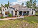 Beautiful home with a well-manicured lawn, featuring a stone pathway leading to a covered front porch and a bright blue front door at 7415 36Th E Ave, Palmetto, FL 34221