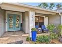 Inviting front porch featuring a tiled floor, cozy seating, a vibrant blue planter, and a stylish double-door entrance at 7415 36Th E Ave, Palmetto, FL 34221