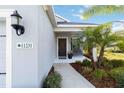 Welcoming front porch with a bench, well-kept garden, and a clear view of the home's address at 11231 Woodlake Way, Parrish, FL 34219