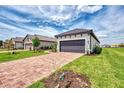 Single Gathering home with a two car garage, paver driveway, green grass and professionally landscaped front yard at 16119 Fortezza Dr, Bradenton, FL 34211