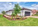 Single Gathering home with a two car garage, paver driveway, green grass and professionally landscaped front yard at 16119 Fortezza Dr, Bradenton, FL 34211
