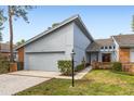 Charming home featuring a two-car garage, light-blue siding, brick accents, and well-manicured landscaping at 2630 Moss Oak Dr # 50, Sarasota, FL 34231