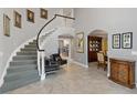 Bright foyer with curved staircase, grey tile flooring, and views into the dining and living areas at 3783 Beneva Oaks Blvd, Sarasota, FL 34238