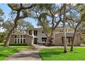 Beautiful two story home featuring stone accents, a circular driveway, and mature landscaping at 3783 Beneva Oaks Blvd, Sarasota, FL 34238