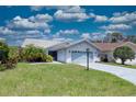 Charming one-story home with light blue garage door, mature landscaping and tile roof at 5974 San Michelle Dr, Sarasota, FL 34243