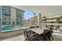 Relaxing covered patio featuring a dining table and views of the pool area at 6512 Midnight Pass Rd # 206, Sarasota, FL 34242