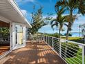 Inviting outdoor deck with white railings, a table with chairs, and scenic water views at 691 Linley St, Longboat Key, FL 34228