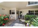 Charming front porch with bistro table, chair, lush plants, and access to the front door at 7860 Palm Aire Ln # 104, Sarasota, FL 34243