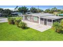 Beautiful home with a screened in porch and large paved patio in a well manicured lawn at 8430 Truman St, Englewood, FL 34224