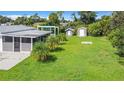 Spacious backyard featuring a covered patio, shade structure, and storage sheds at 8430 Truman St, Englewood, FL 34224