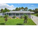 Well-kept single-story home with a lush green lawn and palm tree landscaping at 8430 Truman St, Englewood, FL 34224