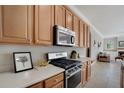 Modern kitchen with stainless steel oven and microwave, surrounded by light countertops and matching cabinets at 14205 Nighthawk Ter, Lakewood Ranch, FL 34202
