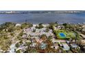 Aerial view of property near waterfront, tennis courts, and community buildings surrounded by mature trees at 1520 2Nd E Ave, Bradenton, FL 34208