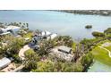 Overhead shot of a waterfront property, surrounded by lush trees and with a tennis court nearby at 1621 Memory Ln, Sarasota, FL 34231