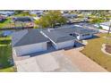 Stunning aerial view of a canal-front home with a paver driveway, separate garage, and nicely landscaped yard at 1950 Fairview Dr, Englewood, FL 34223