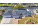 Beautiful aerial view of a canal-front home with a pool, and a separate garage, and nicely landscaped yard at 1950 Fairview Dr, Englewood, FL 34223