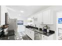 Modern kitchen with white cabinets, black countertop, and stainless-steel appliances at 2312 Java Plum Ave, Sarasota, FL 34232
