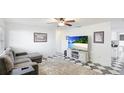 Bright living room with a ceiling fan, checkered floors, and comfortable gray seating at 2312 Java Plum Ave, Sarasota, FL 34232