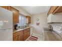 Charming kitchen featuring wood cabinetry, granite countertops, stainless steel sink, and white appliances at 2620 Hidden Lake N Dr # B, Sarasota, FL 34237