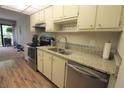 Bright kitchen with stainless steel appliances, granite countertops, tile backsplash, and wood-look flooring at 425 30Th W Ave # C210, Bradenton, FL 34205