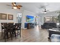 Open-concept living room with modern furniture, ceiling fans, and seamless flow to adjacent dining areas at 4630 56Th E Dr, Bradenton, FL 34203