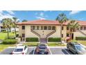 Condo building featuring a well-maintained exterior, palm trees, and convenient parking spaces at 5187 Lake Village Dr # 4, Sarasota, FL 34235