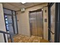 Interior view of building's elevator, with tile flooring and emergency exit sign at 5611 Gulf Of Mexico Dr # 5, Longboat Key, FL 34228