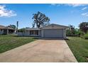 Charming single-story home with a two-car garage, a well-kept lawn, and mature landscaping at 927 Lemon Bay Dr, Venice, FL 34293