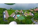 Aerial view of a waterfront community with pool, tennis courts, boat docks and lush landscaping at 4234 Gulf Of Mexico Dr # E2, Longboat Key, FL 34228