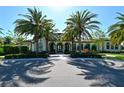 Elegant home with a grand entrance, arched doorways, lush landscaping, and stately palm trees along the driveway at 552 Bocelli Dr, North Venice, FL 34275