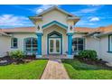 Inviting home entrance with blue accents, detailed trim, and brick walkway at 5750 Saddle Oak Trl, Sarasota, FL 34241