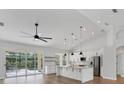 Modern kitchen with white cabinets, stainless steel appliances, an island with pendant lighting, and views of the pool at 6832 Bay Hill Dr, Lakewood Ranch, FL 34202